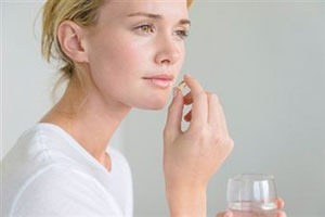 женщина пьет таблетку