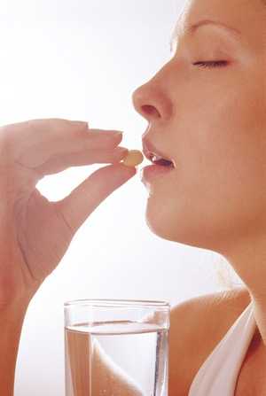 девушка пьет таблетку