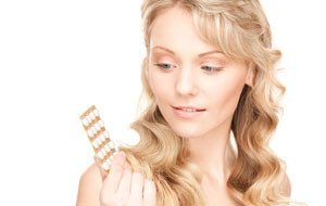 девушка поглядывает на таблетки