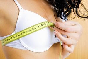 девушка обмеряет свой бюст сантиметром